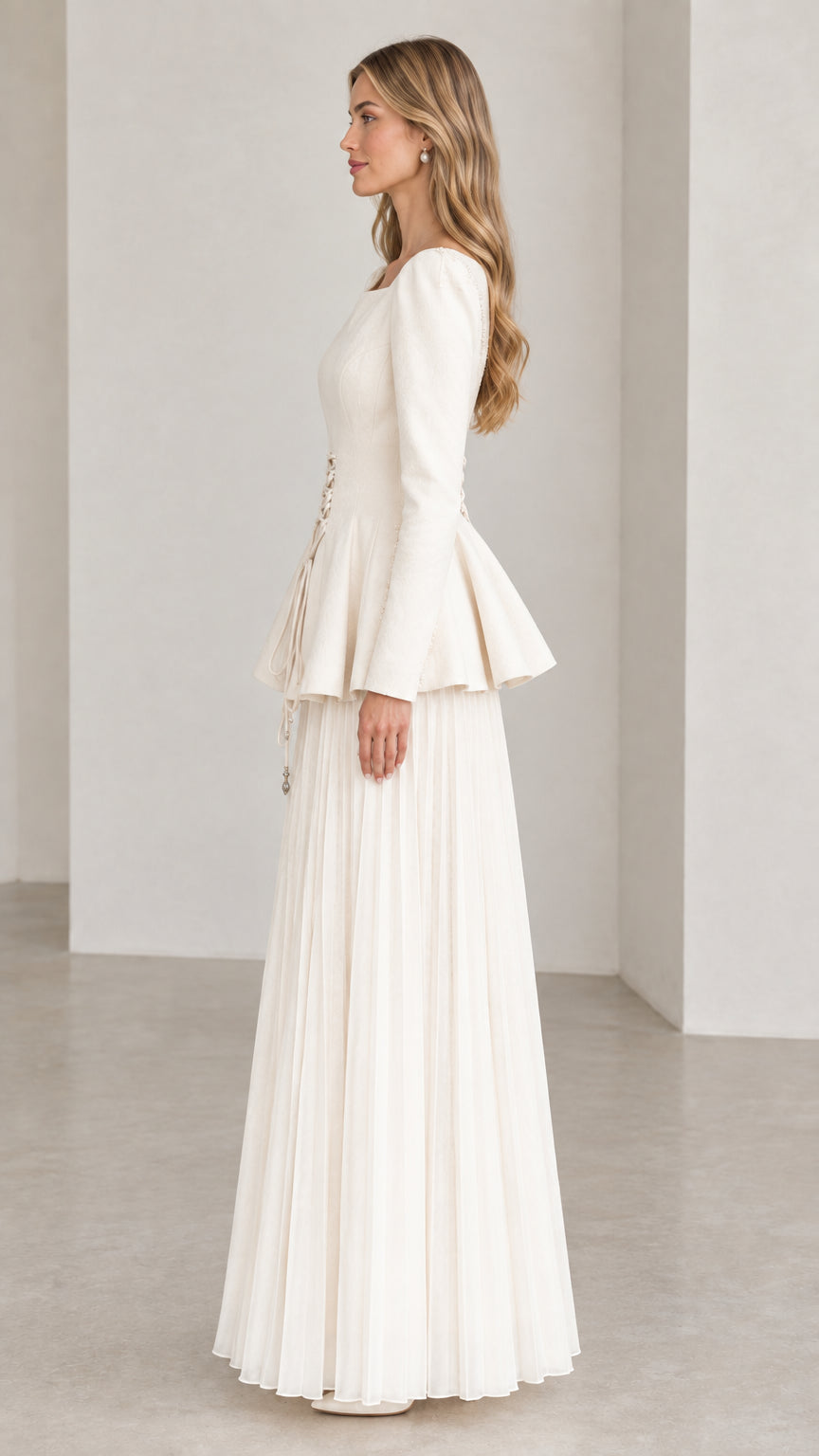 Off-white long sleeve peplum dress side view showing pleated maxi skirt