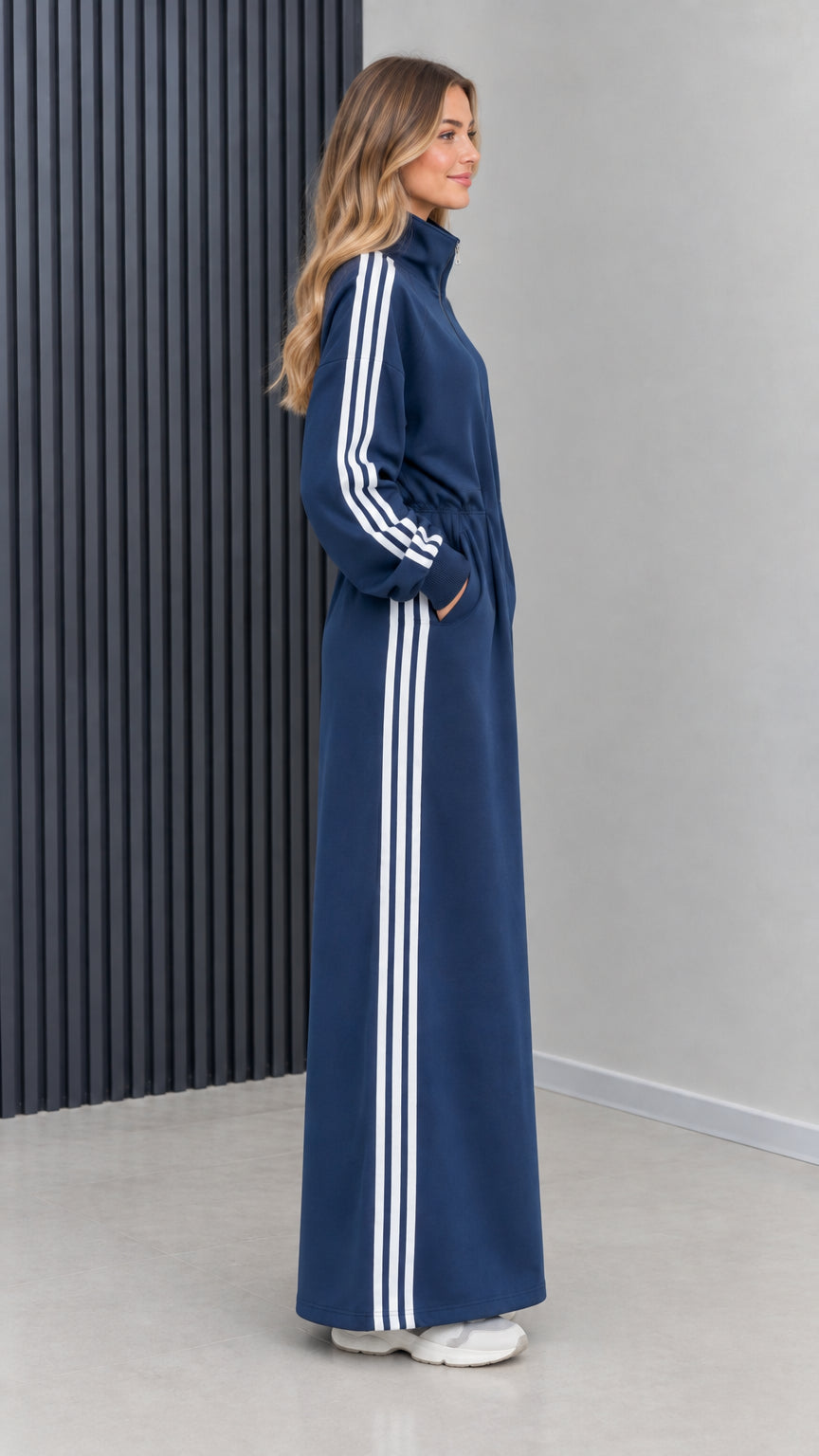 Side profile view of navy blue full-length athletic stripe track dress