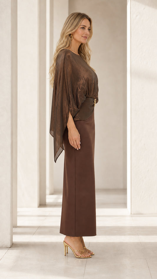 Side profile of woman wearing bronze brown cape overlay column evening gown