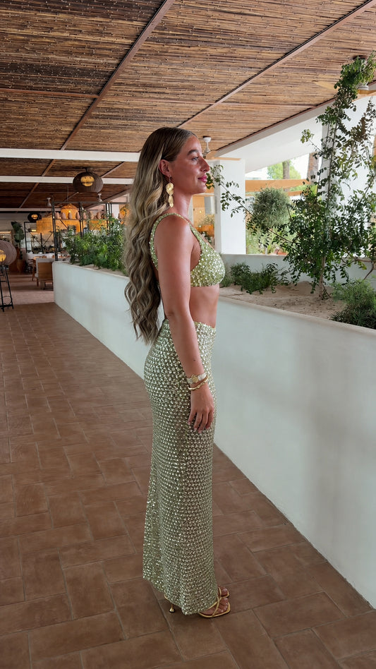 Side profile of model in sage green sequin crop top and maxi skirt