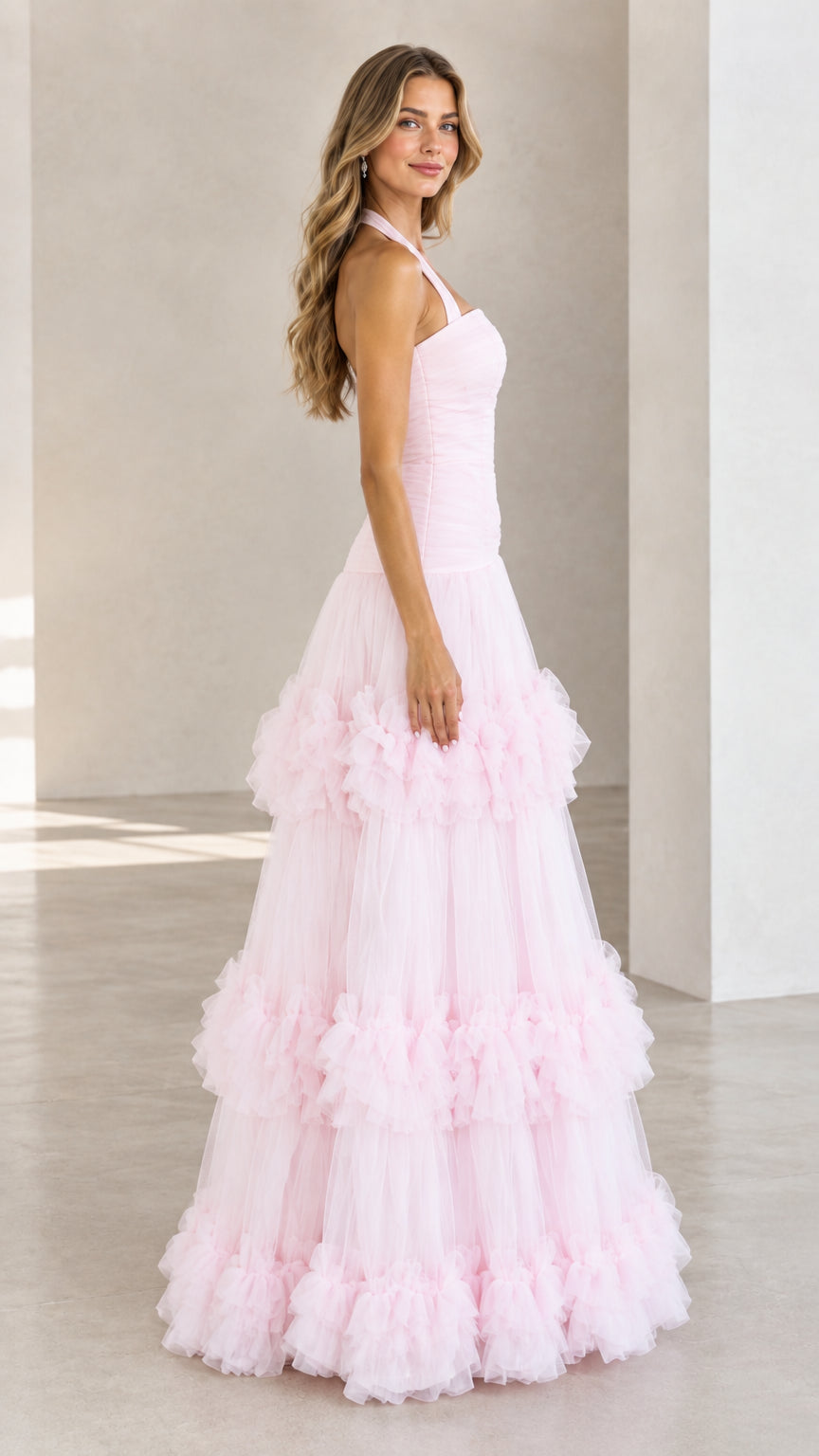 Side profile of woman in Light Pink halter tiered tulle maxi ball gown