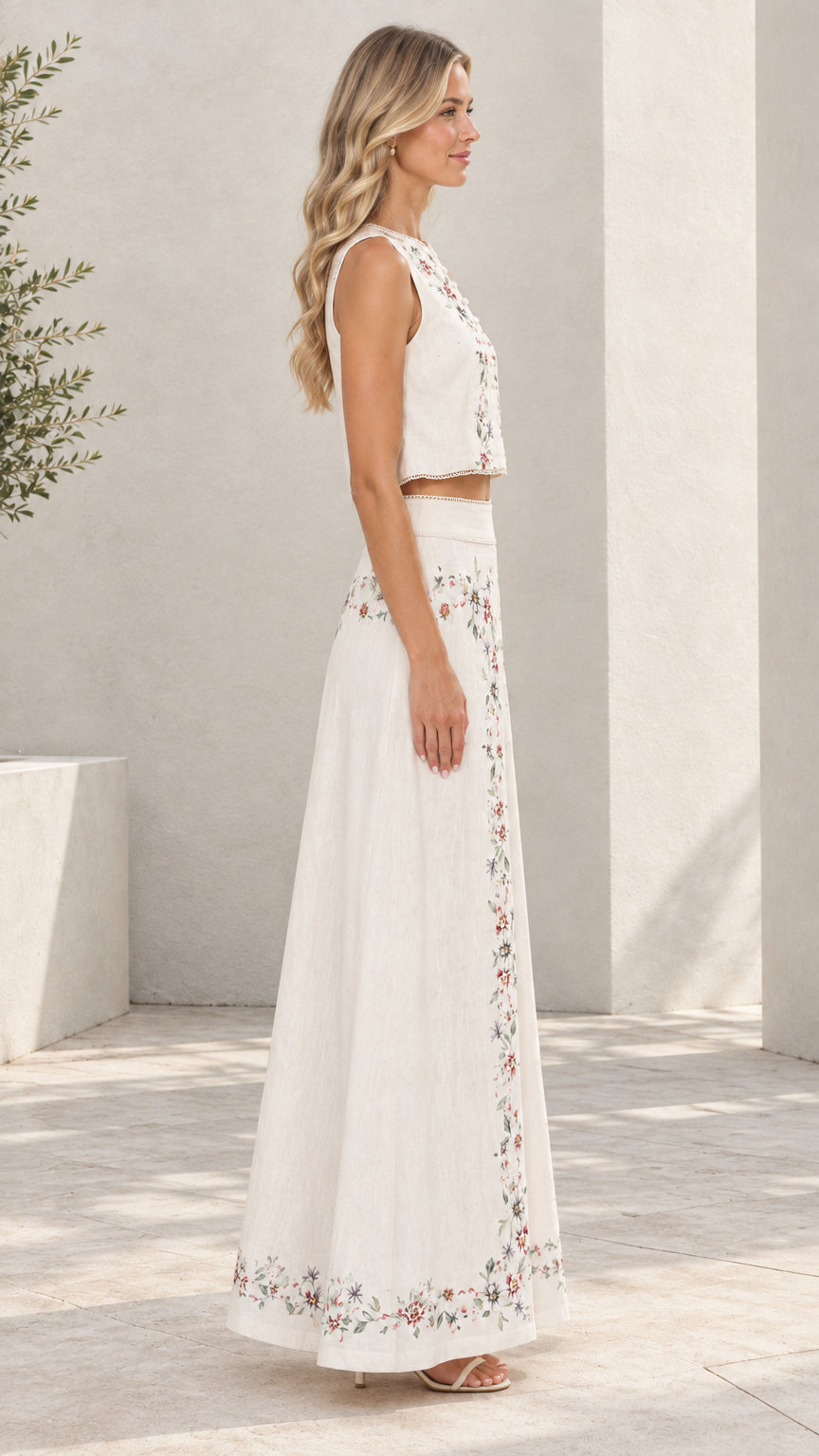 Side profile of model wearing white embroidered matching top and skirt set