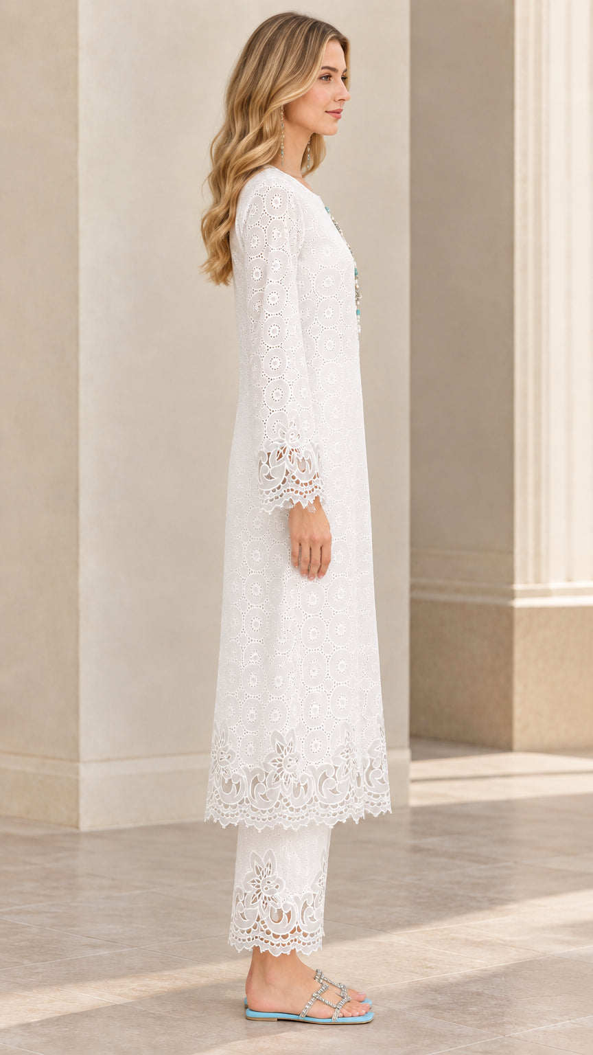 Side profile view of woman modeling white embroidered tunic set with scalloped hems