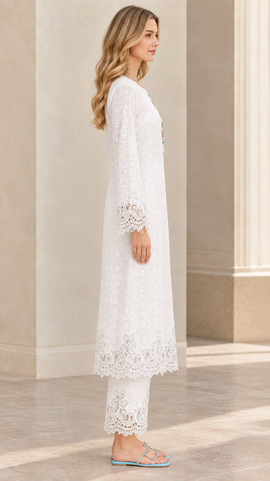 Side profile view of woman modeling white embroidered tunic set with scalloped hems