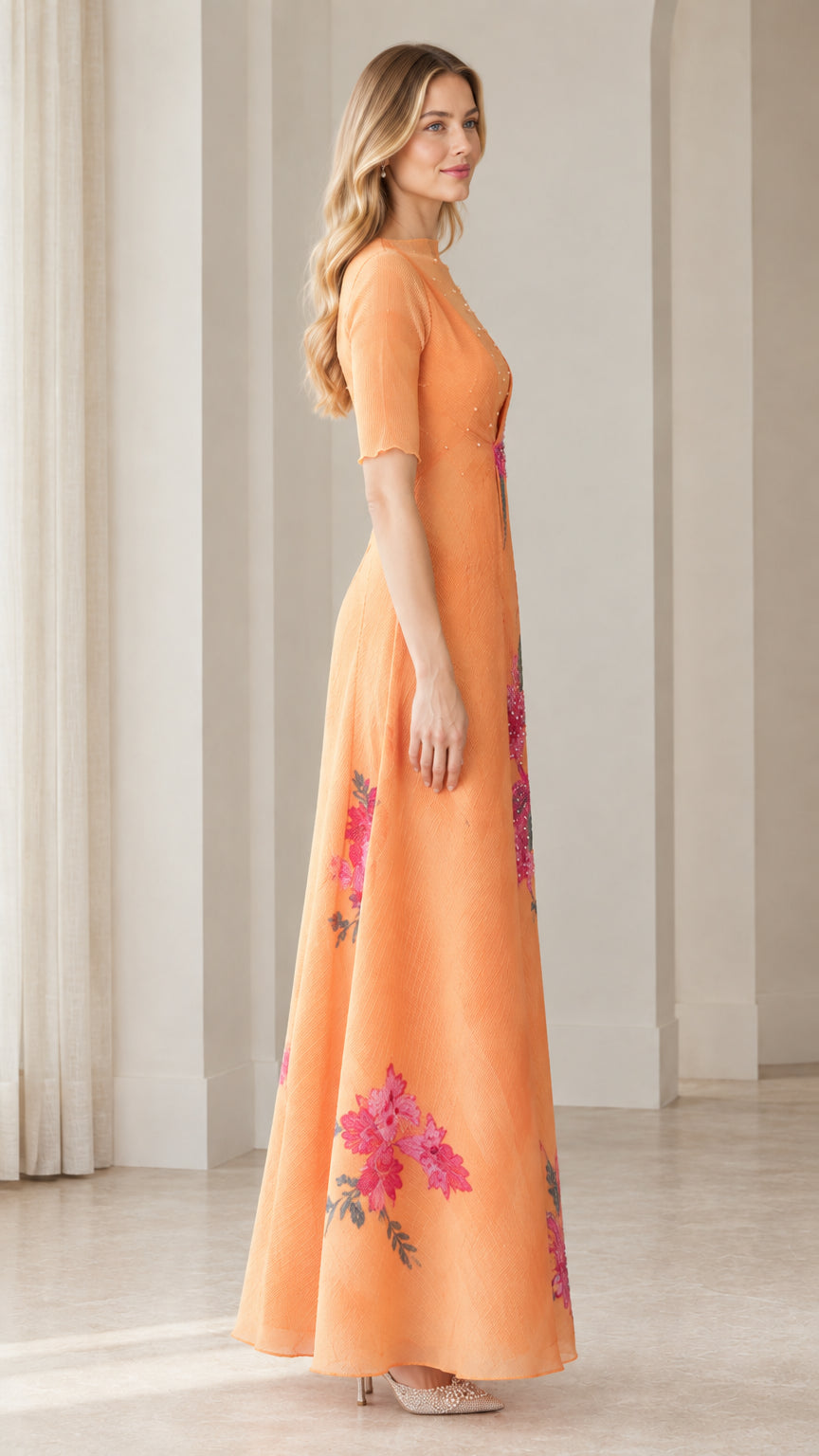 Side view of apricot orange embroidered evening dress showcasing floor-length drape