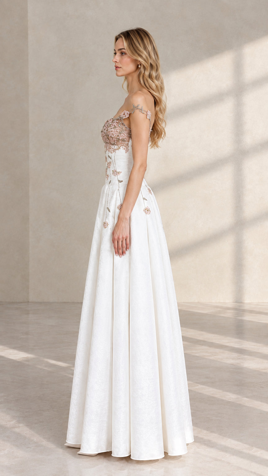 Side profile of white floral embroidered formal gown showcasing fitted bodice and flowing skirt