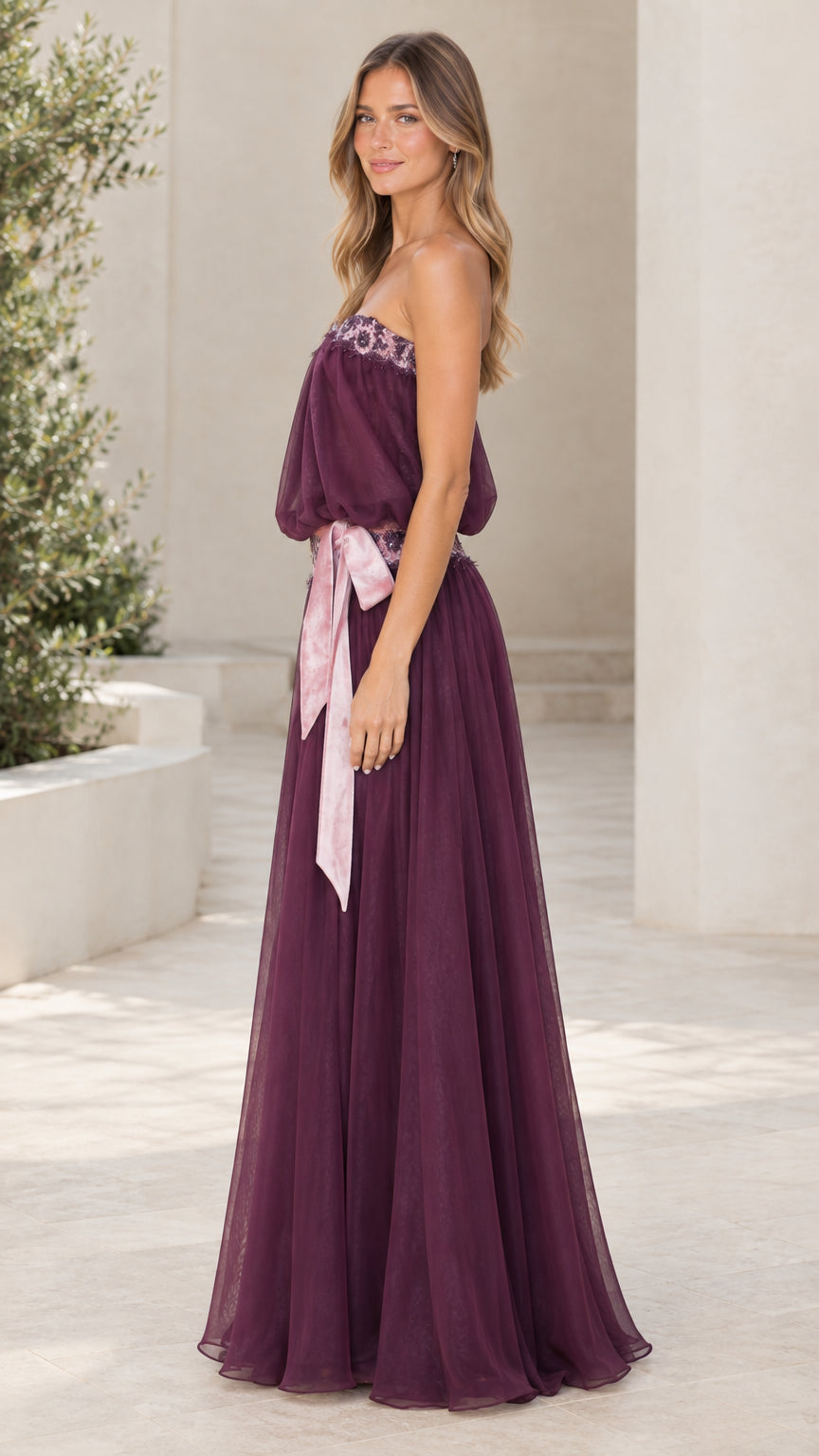 Model wearing Plum strapless blouson evening gown side view
