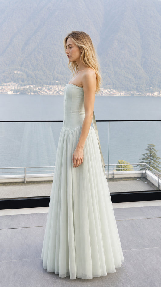 Side profile view of sage green strapless corset tulle dress outdoors