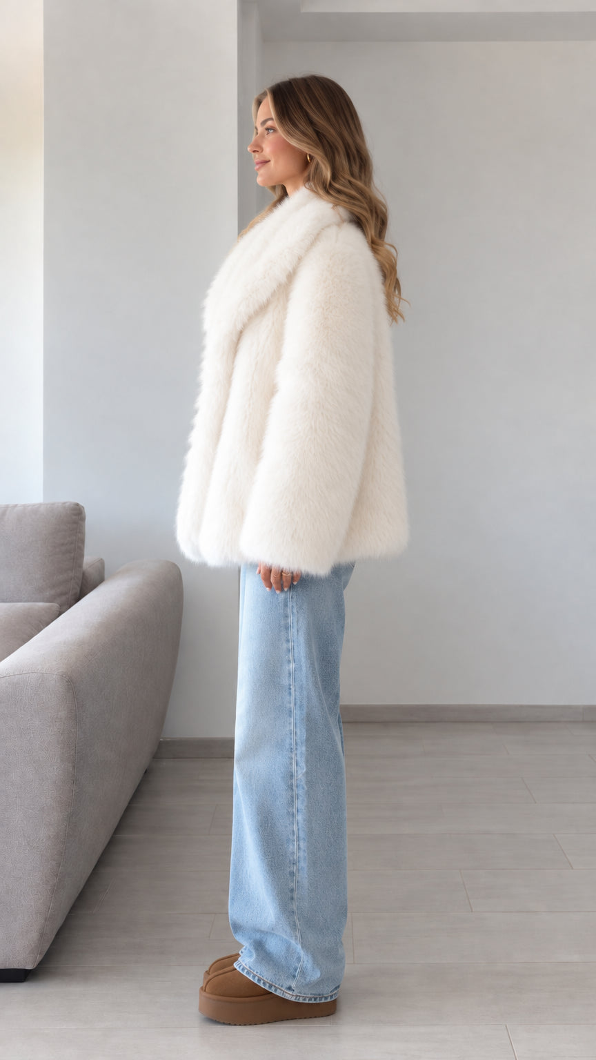 Side profile view of model wearing ivory plush faux fur winter coat