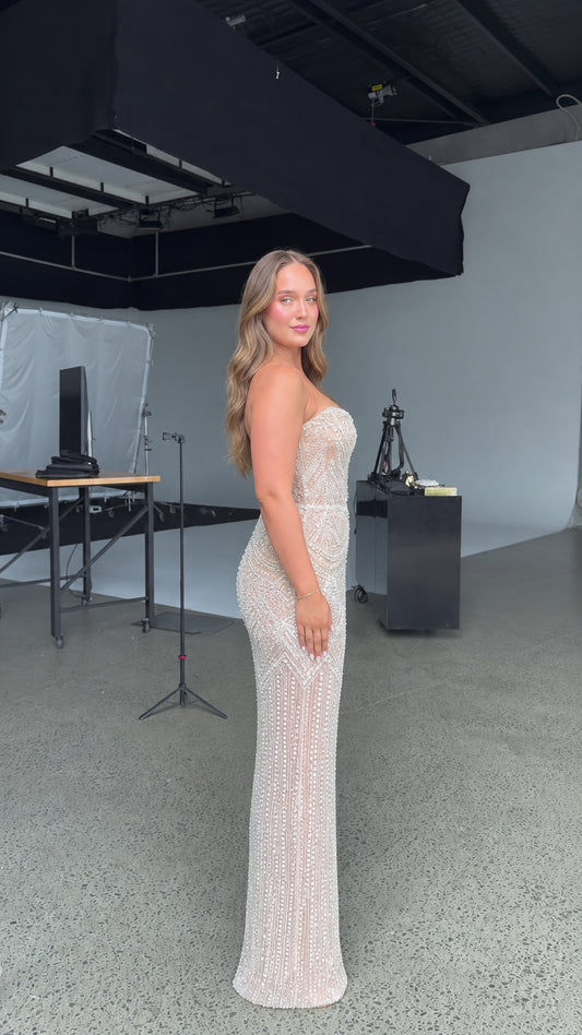 Side profile view of model wearing champagne embellished maxi dress