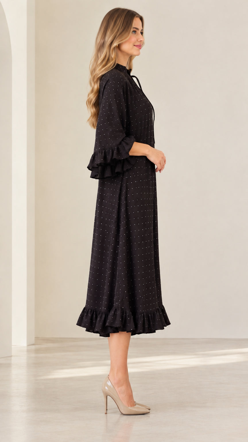 Side profile of woman wearing black sparkle ruffle midi dress