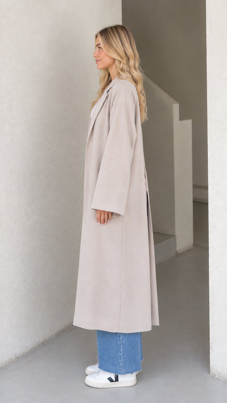 Side profile view of model showcasing long drape and clean lines of Light Grey duster coat