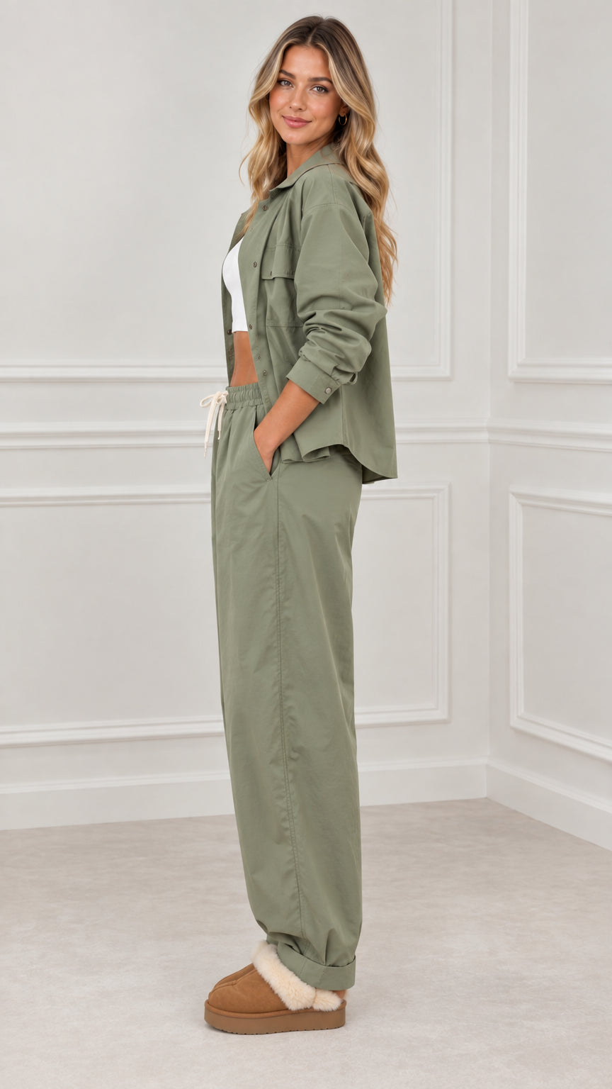 Side full view of woman wearing sage green utility pant set with white inner top
