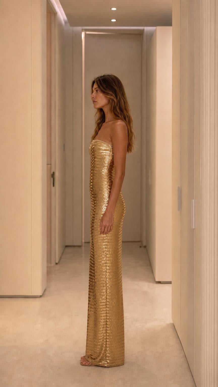 Side profile of model wearing gold sequin dress