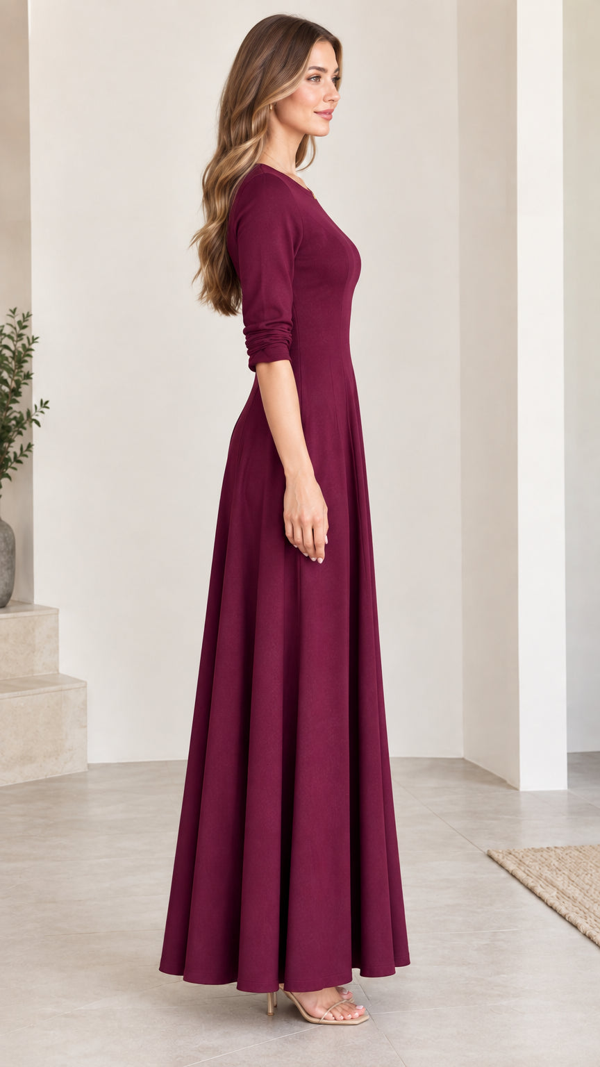 Side angle view of woman modeling long burgundy flared maxi dress