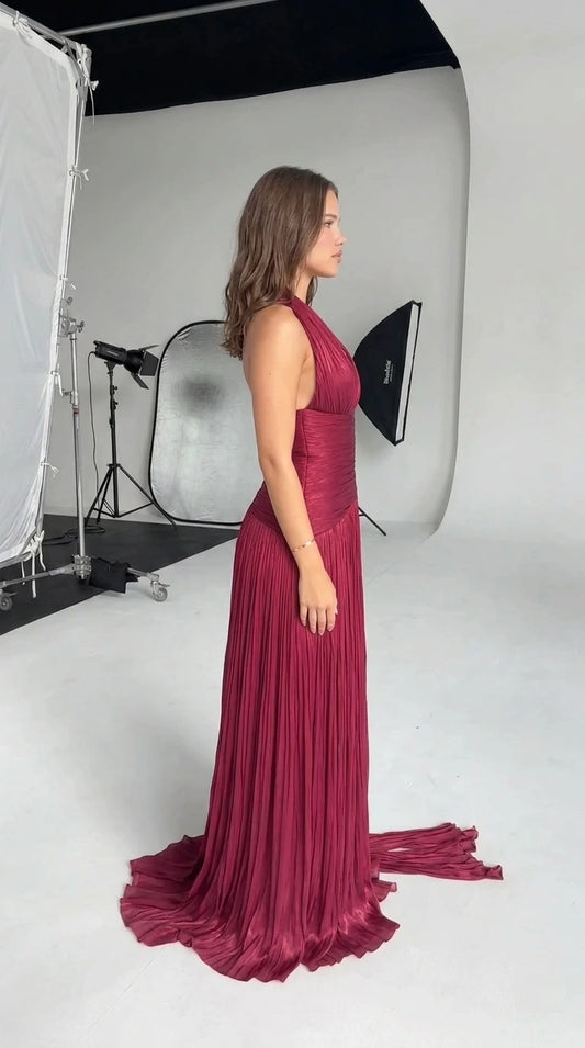Side profile view of burgundy ruched halter formal dress showing flowing silhouette