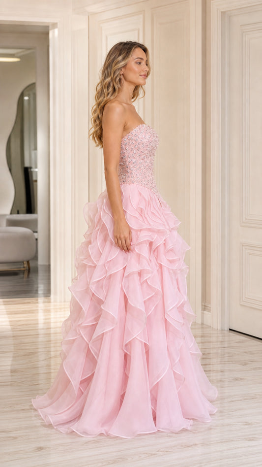 Side angle view of model posing in baby pink beaded formal ball gown