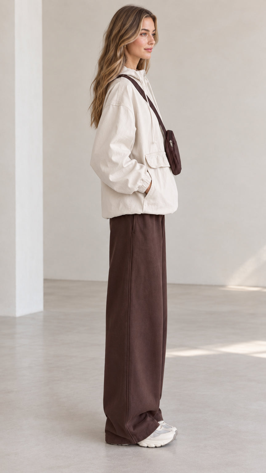 Side profile view of model in beige casual hooded anorak jacket