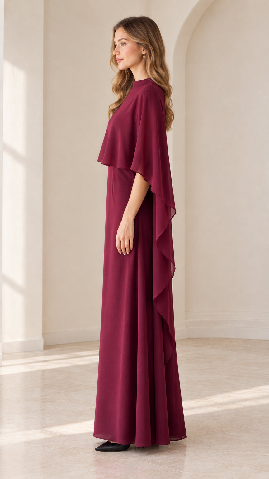 Side view of burgundy floor-length cape evening gown
