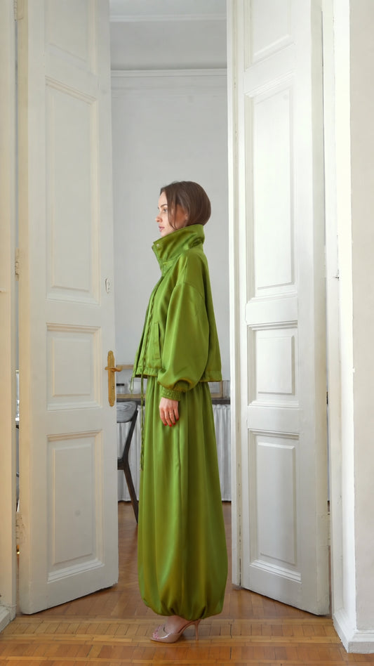 Side profile view of model wearing lime green matching jacket and pant set