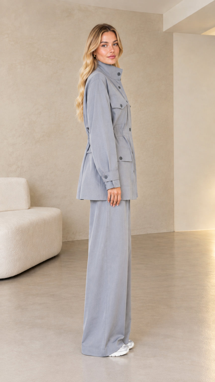 Side profile view of model in dusty blue two-piece utility suit