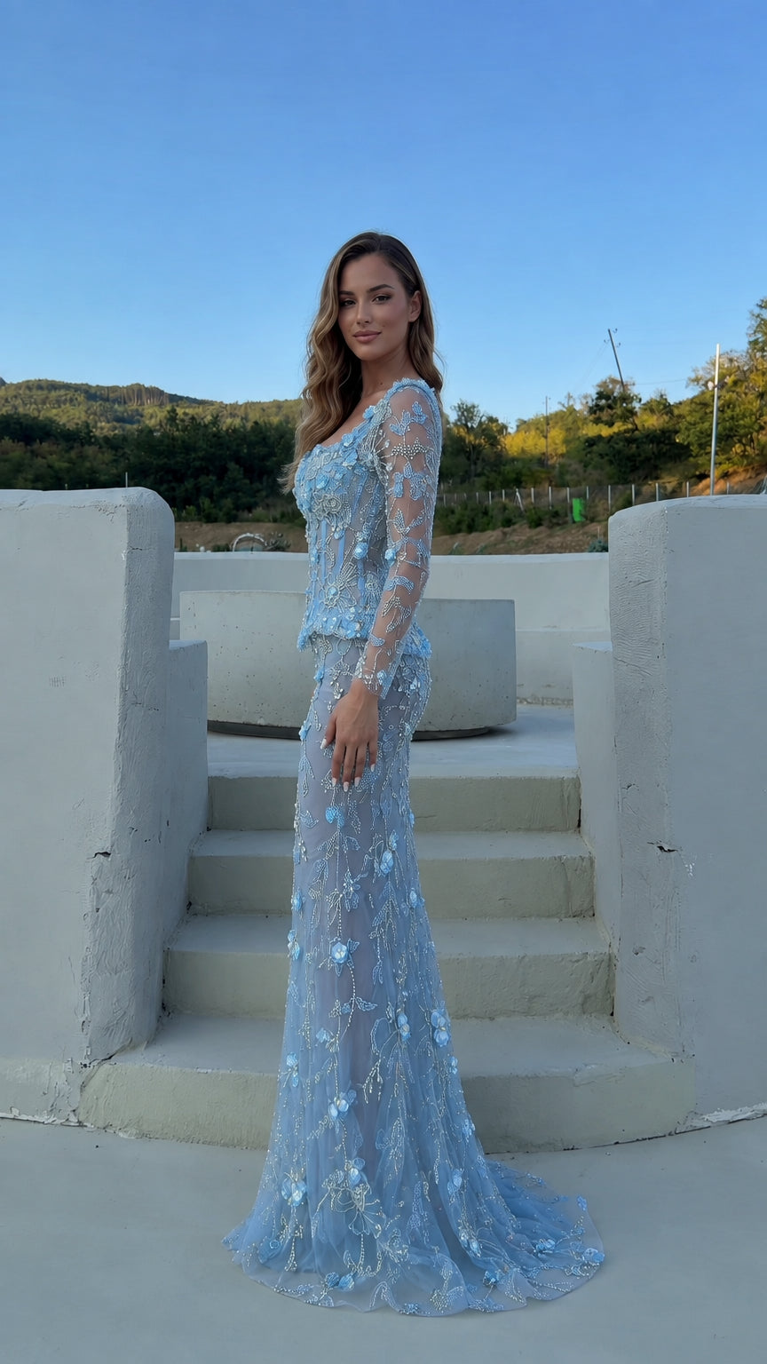 Side profile of the light blue long sleeve mermaid formal gown with trailing hem