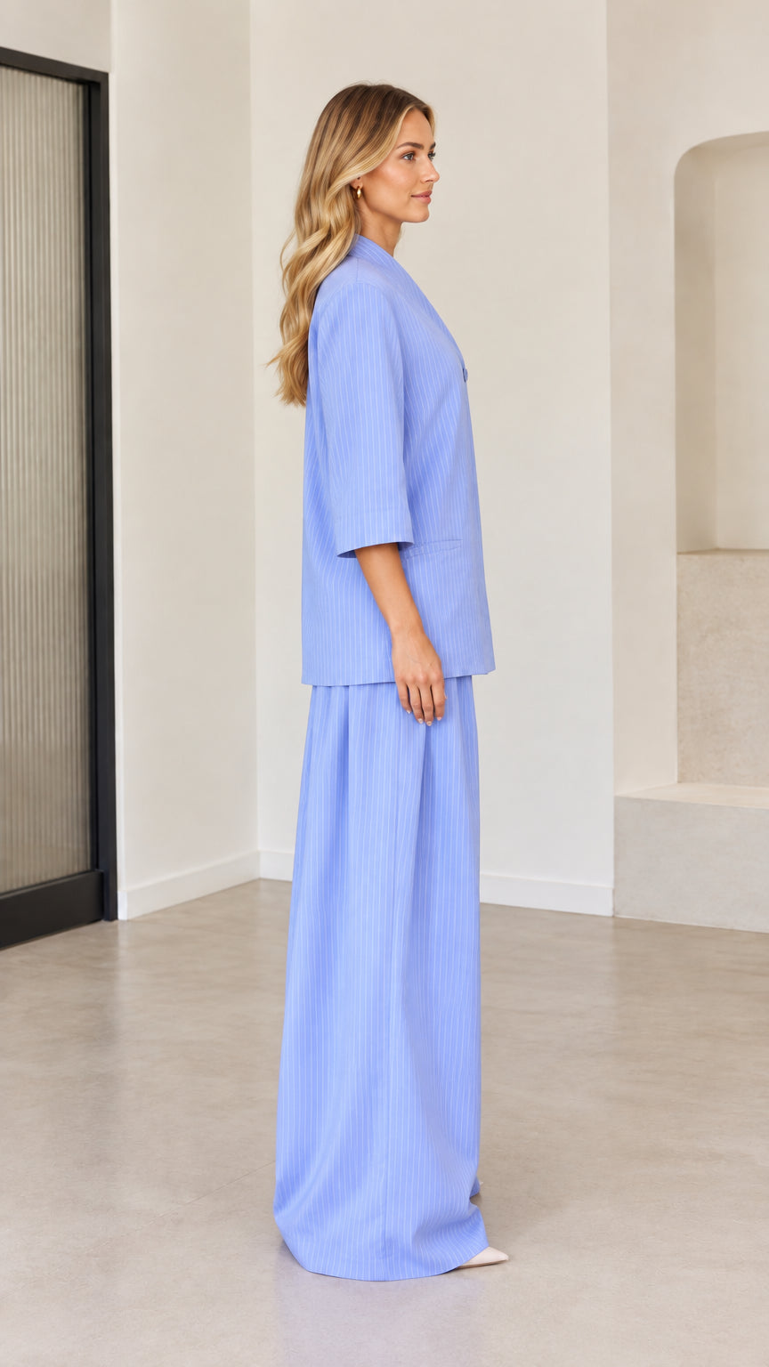 Side profile of woman wearing light blue pinstripe matching pantsuit set
