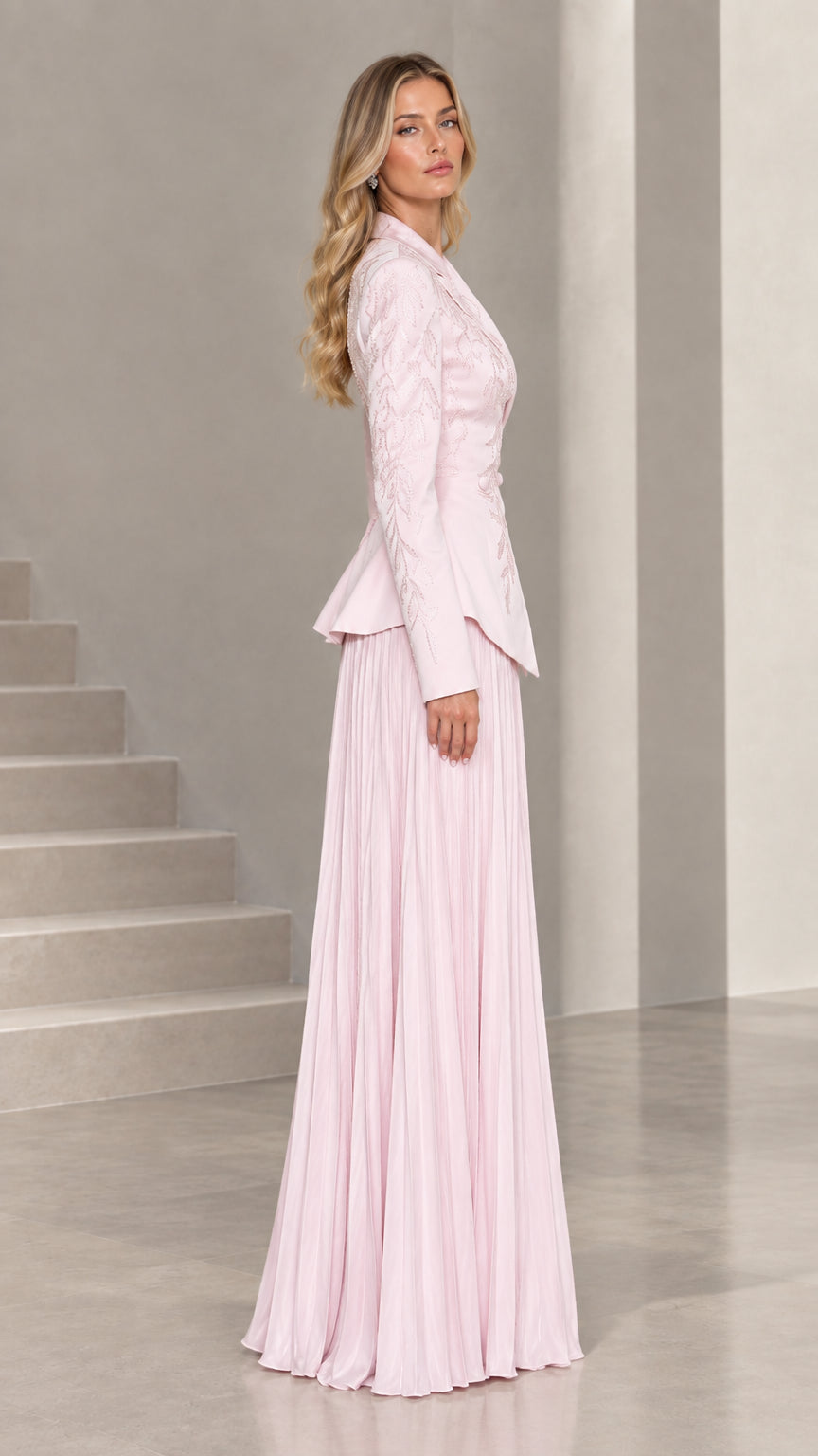 Side profile view of blush pink peplum jacket and accordion pleated formal skirt