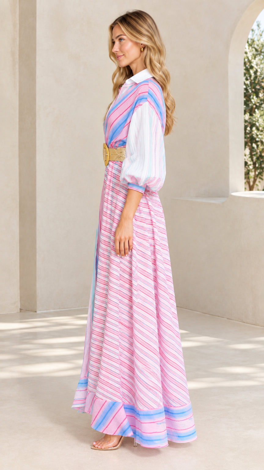 Side profile of woman wearing pink multi striped collared maxi dress