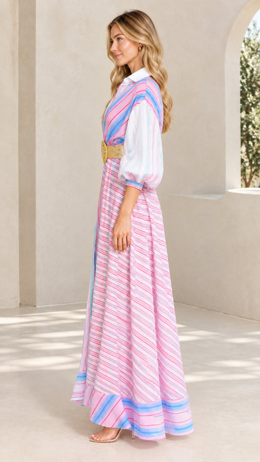 Side profile of woman wearing pink multi striped collared maxi dress