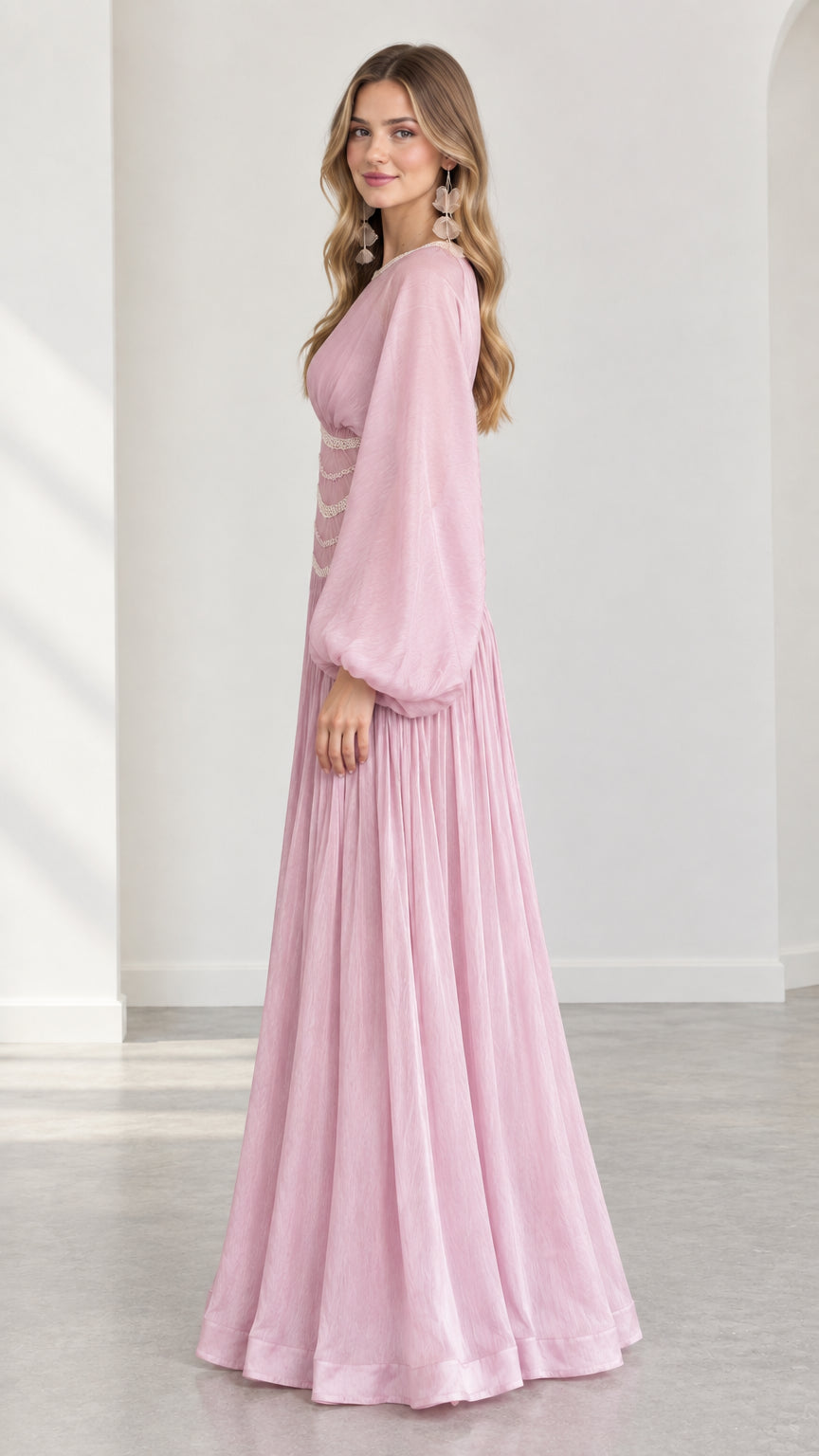 Side angle view of model in flowing pink long-sleeve maxi gown