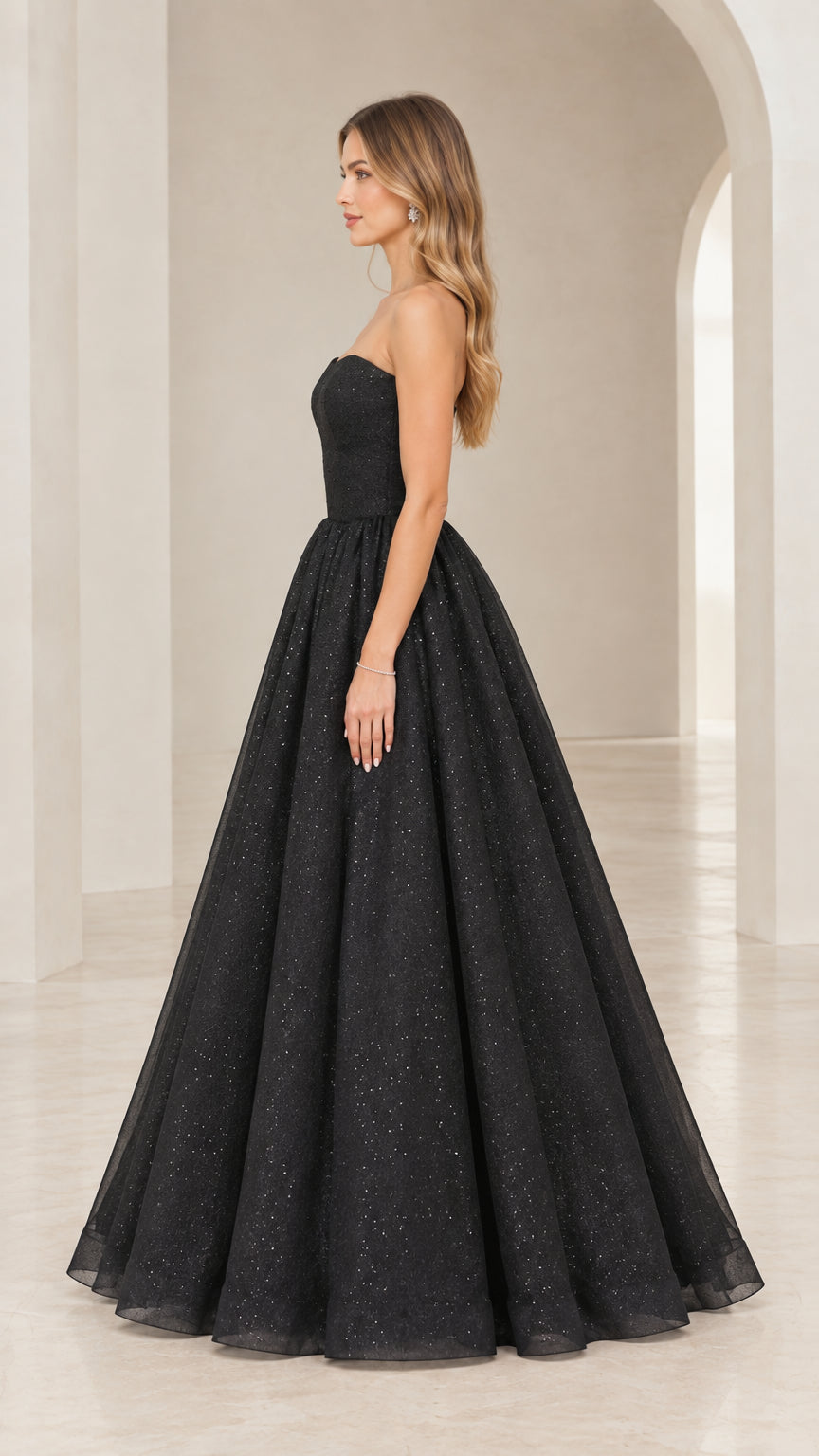 Side view of model posing in black strapless formal evening dress