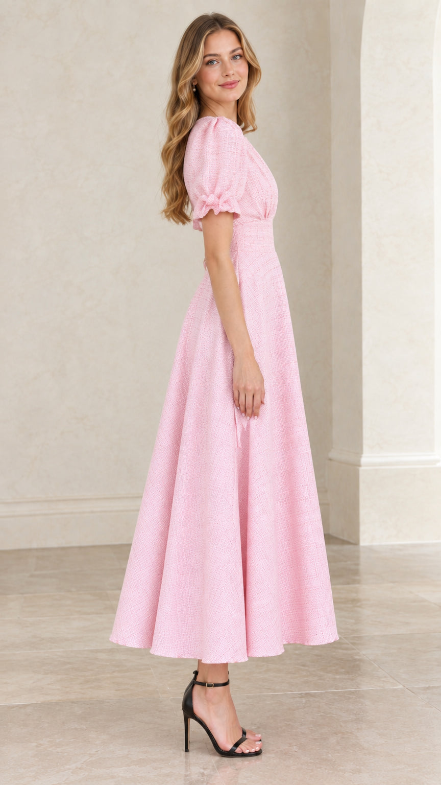 Side angle of model in pastel pink puff sleeve A-line midi dress