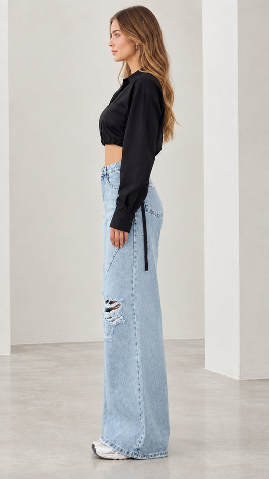 Side view of woman wearing black cropped button up blouse showing side tie strap detail