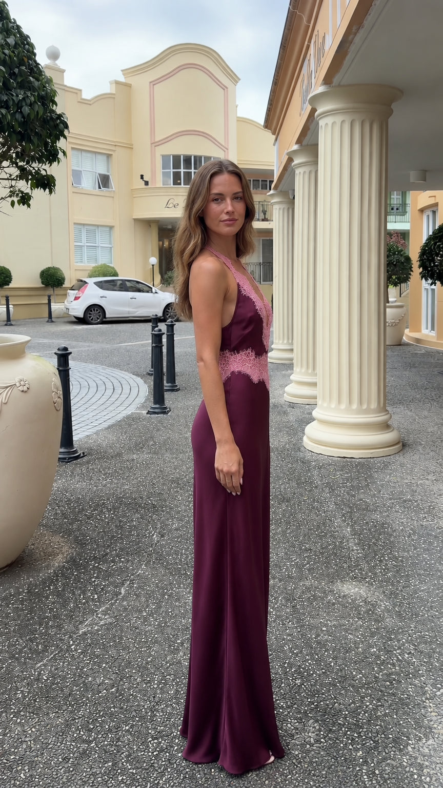 Side profile view of burgundy lace-trimmed halter satin maxi dress