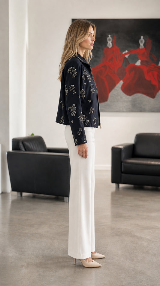 Woman wearing Navy embellished floral zip-up jacket, side profile view