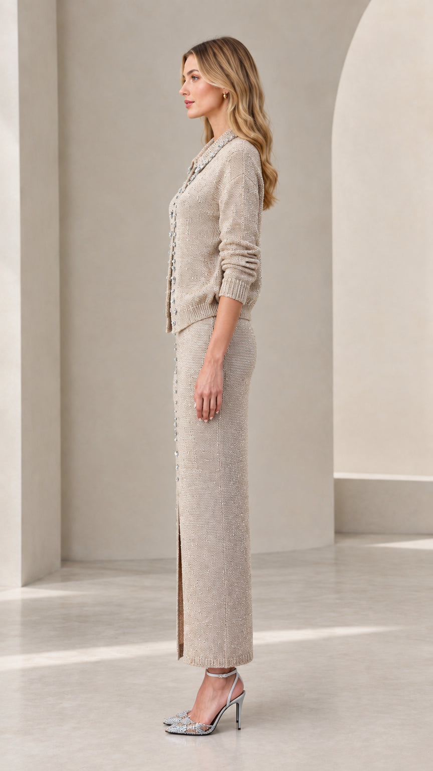 Side view of woman wearing beige knit cardigan and slit maxi skirt set