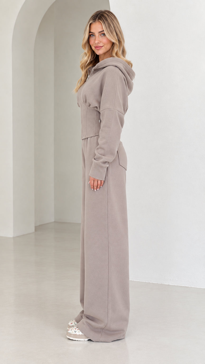 Side profile view of taupe corset tracksuit set showcasing tailored silhouette