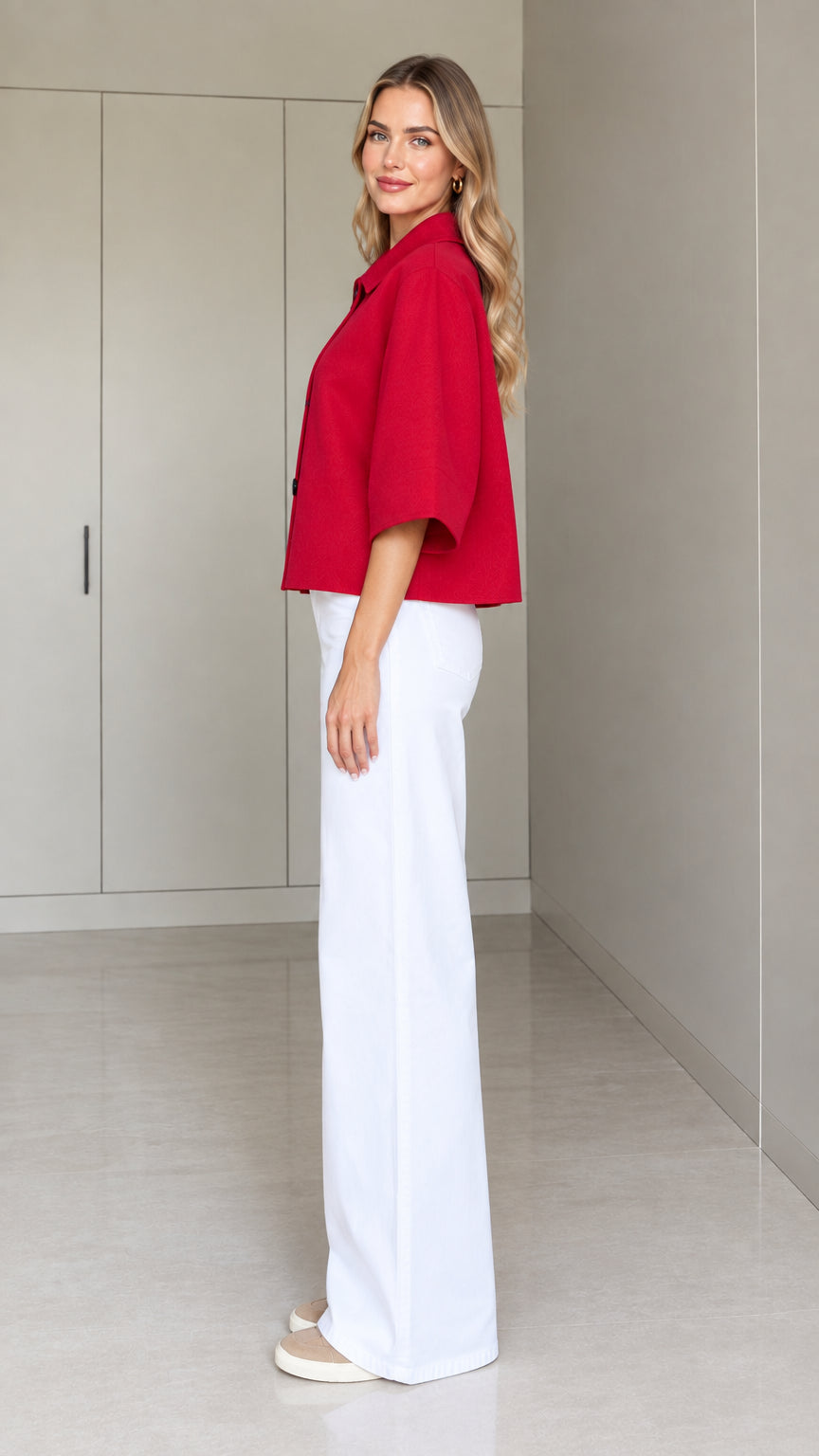Side full-length view of a woman wearing a red cropped swing jacket with wide flared half sleeves
