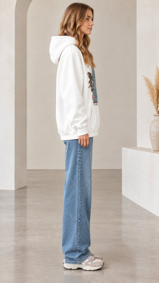 Side profile view of woman wearing white vintage graphic hoodie and jeans