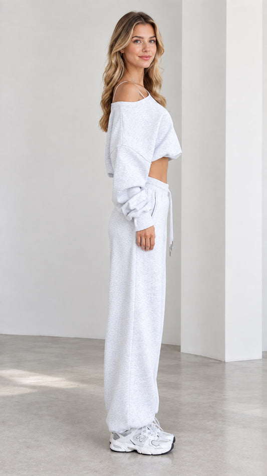 Side profile view of model wearing heather grey two-piece crop sweatshirt and jogger set