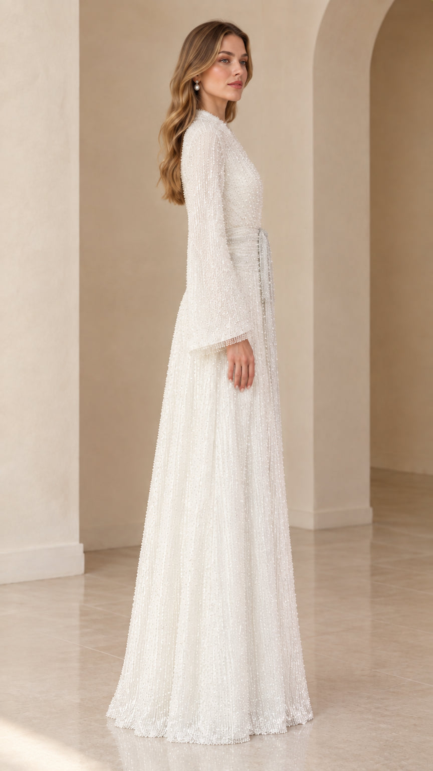 Side profile of model in white shimmering floor-length sequin gown with flared sleeves