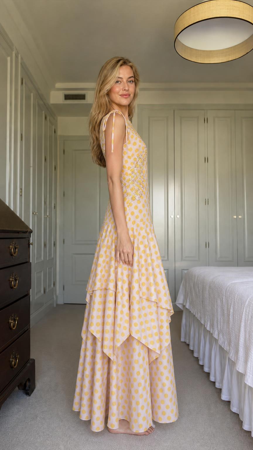 Side profile of model in yellow polka dot maxi dress