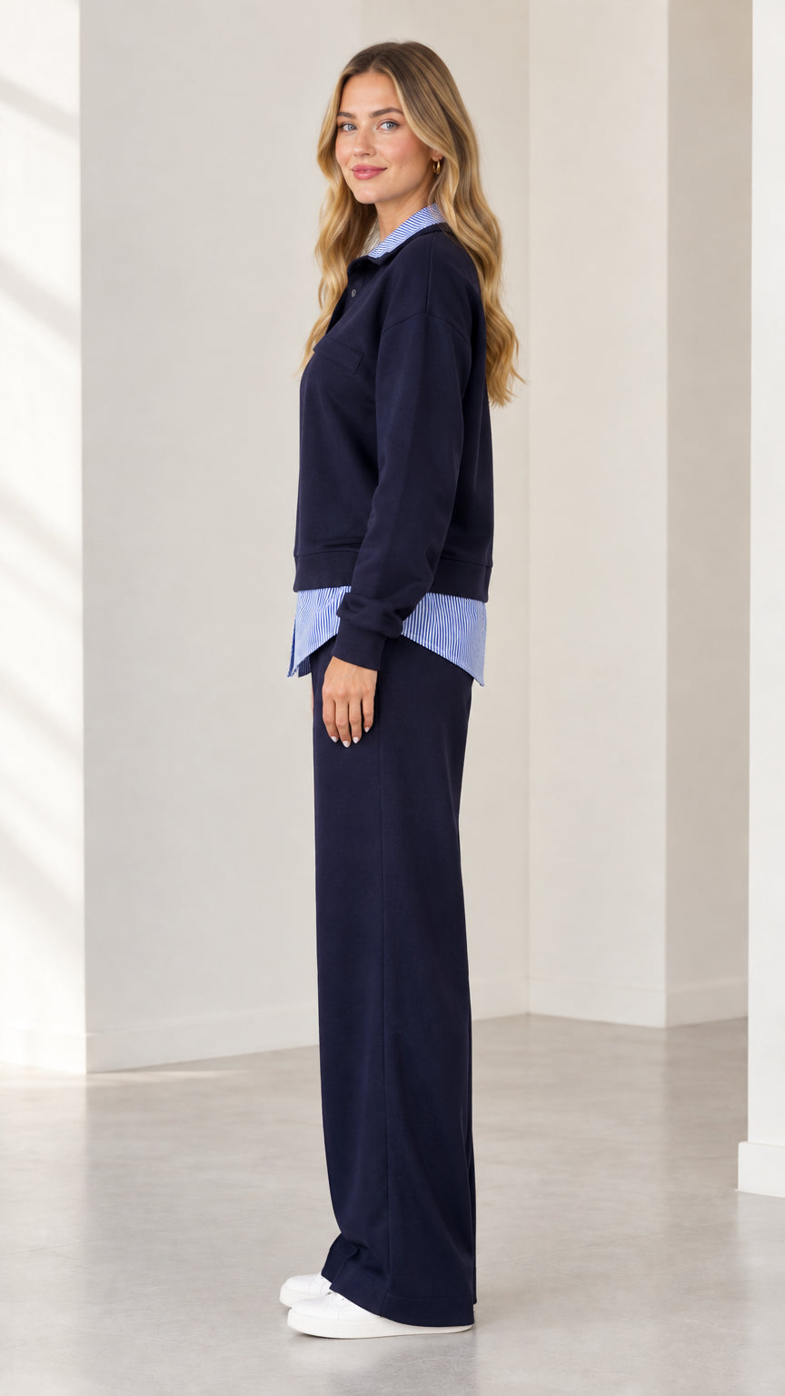 Side profile view of navy blue layered sweatshirt and wide leg trousers set