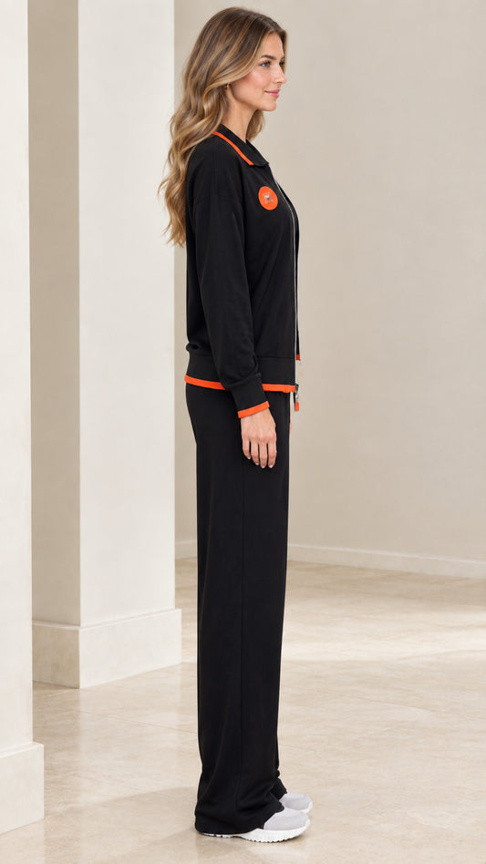 Side profile view of model in black loungewear set with zip jacket and wide-leg pants