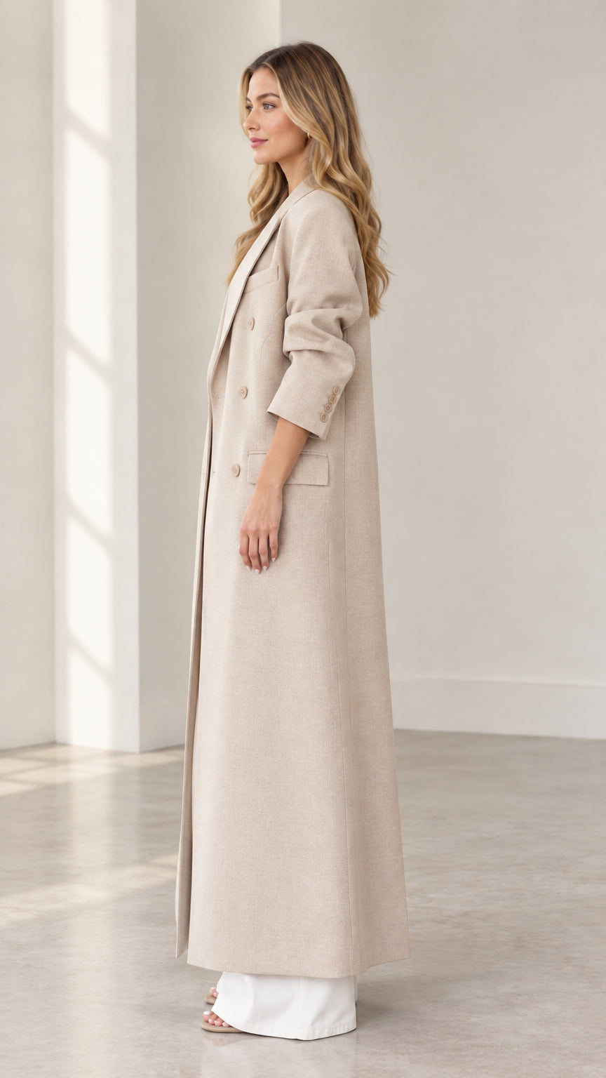 Side profile view of beige longline maxi tailored coat