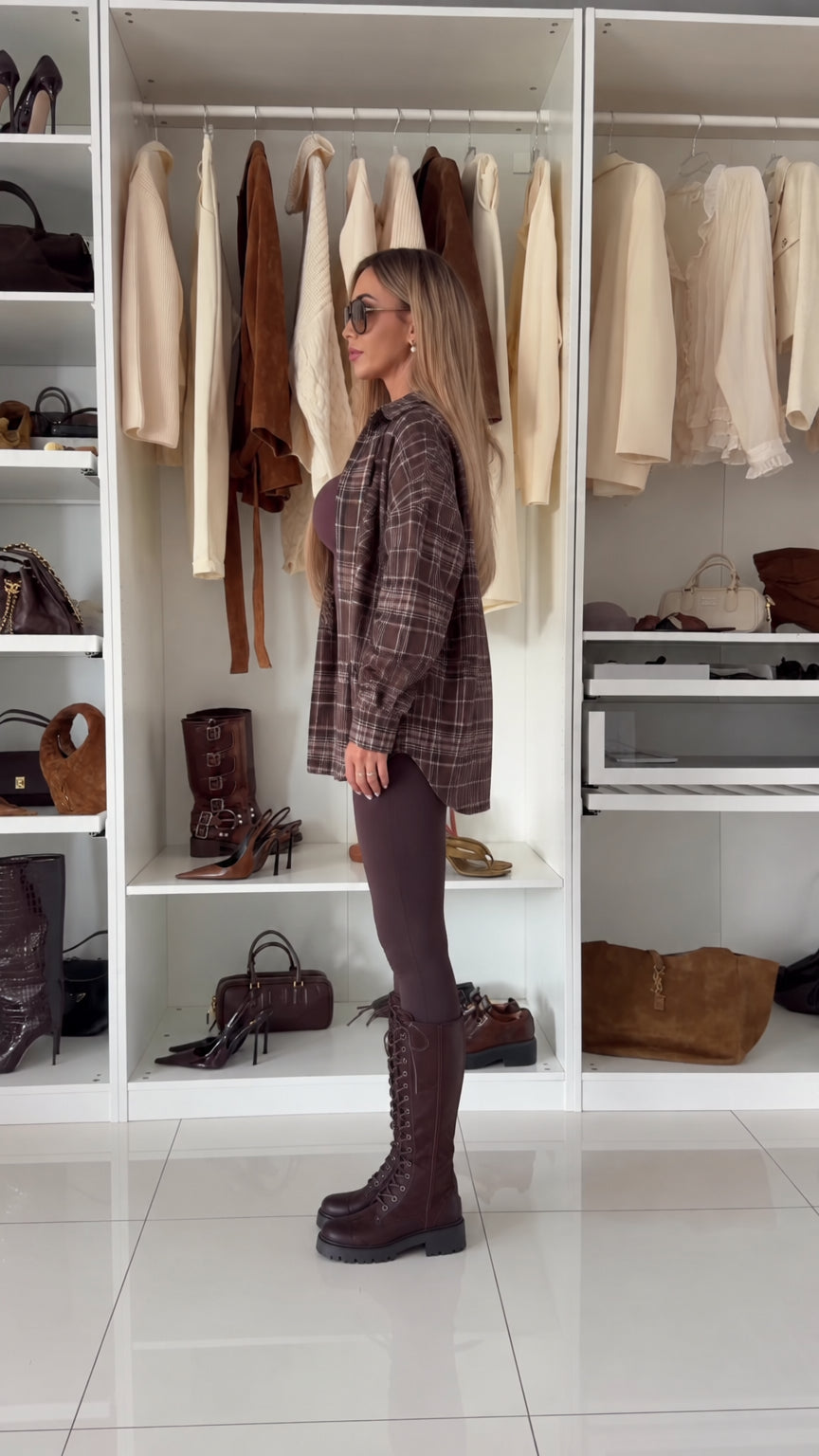 Side profile view of relaxed brown plaid long sleeve button-down shacket
