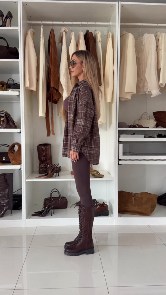 Side profile view of relaxed brown plaid long sleeve button-down shacket