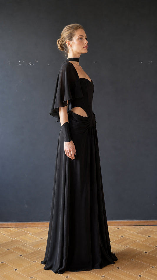 Side profile view of black evening gown showing draped shoulder