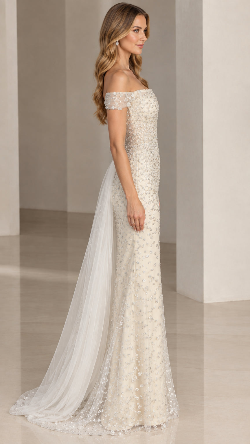 Side profile view of ivory beaded formal gown showing attached side tulle overskirt